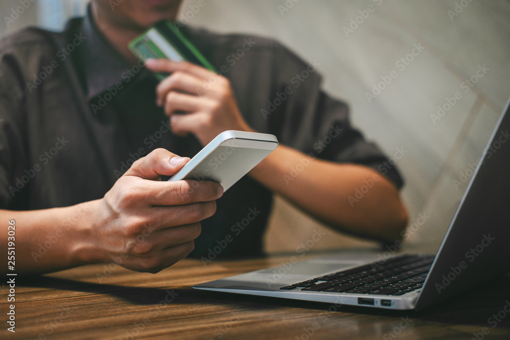 Fototapeta premium Businessman holding credit card and typing on laptop for online shopping and payment makes a purchase on the Internet, Online payment, Business financial and technology
