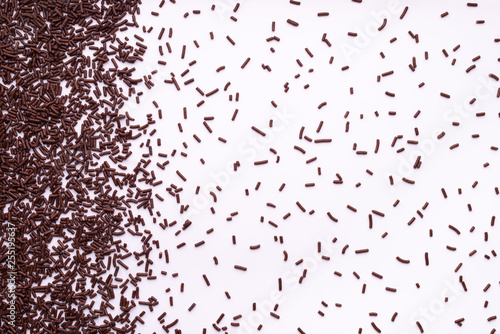 chocolate sprinkle dots, decoration over white background, flat lay