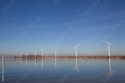 Modern windmills in the water near the shore in the netherlands