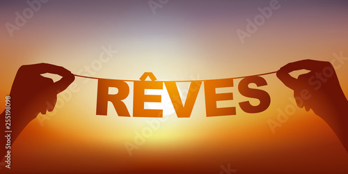 Concept du rêve et de l’imagination, avec deux mains qui tiennent une guirlande sur laquelle est écrit le mot rêve, devant un ciel ensoleillé.