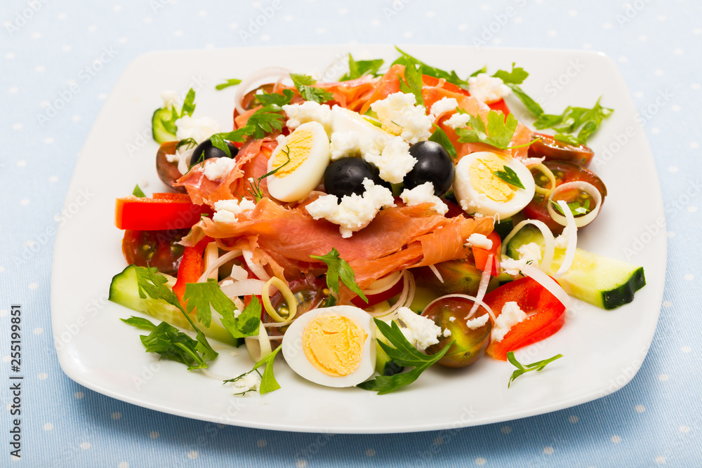 Salad with salmon, fresh  tomato, cucumber and  quail eggs at plate