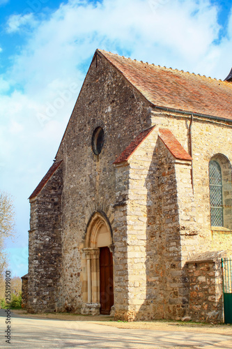 Medieval church in pale stone with carved gothic style porch View of a place of Christian religious worship in the countryside