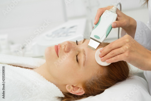 Close up of a young attractive woman getting ultrasonic facial skin cleansing treatment by professional cosmetologist beautician dermatology cosmetology skincare clean fresh rejuvenation wellness
