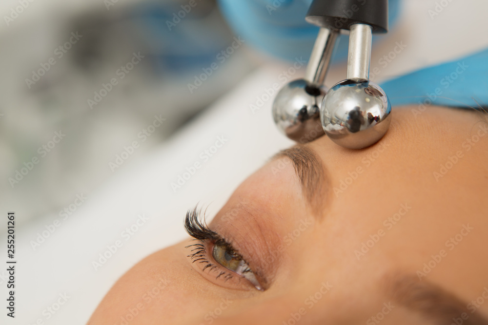Cropped close up of a woman getting microcurrent skincare facial treatment tightening lifting