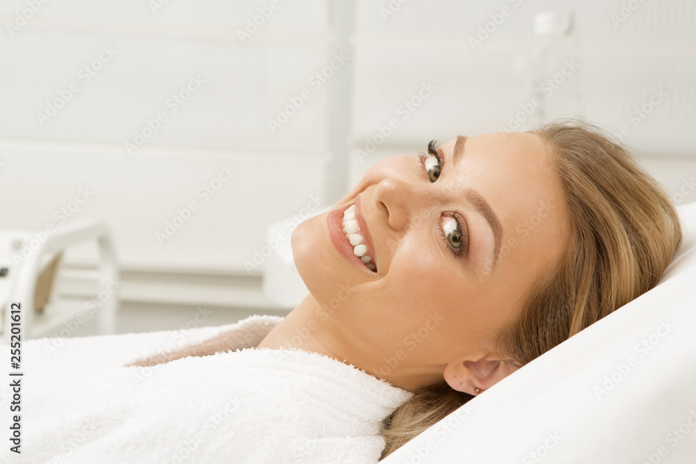 Gorgeous happy and healthy young woman smiling cheerfully to the camera wearing toweling robe lying at the spa salon copyspace beauty beautician cosmetology happiness lifestyle skincare flawless Gorgeous happy and healthy young woman smiling cheerfully to the camera wearing toweling robe lying at the spa salon copyspace beauty beautician cosmetology happiness lifestyle skincare flawless