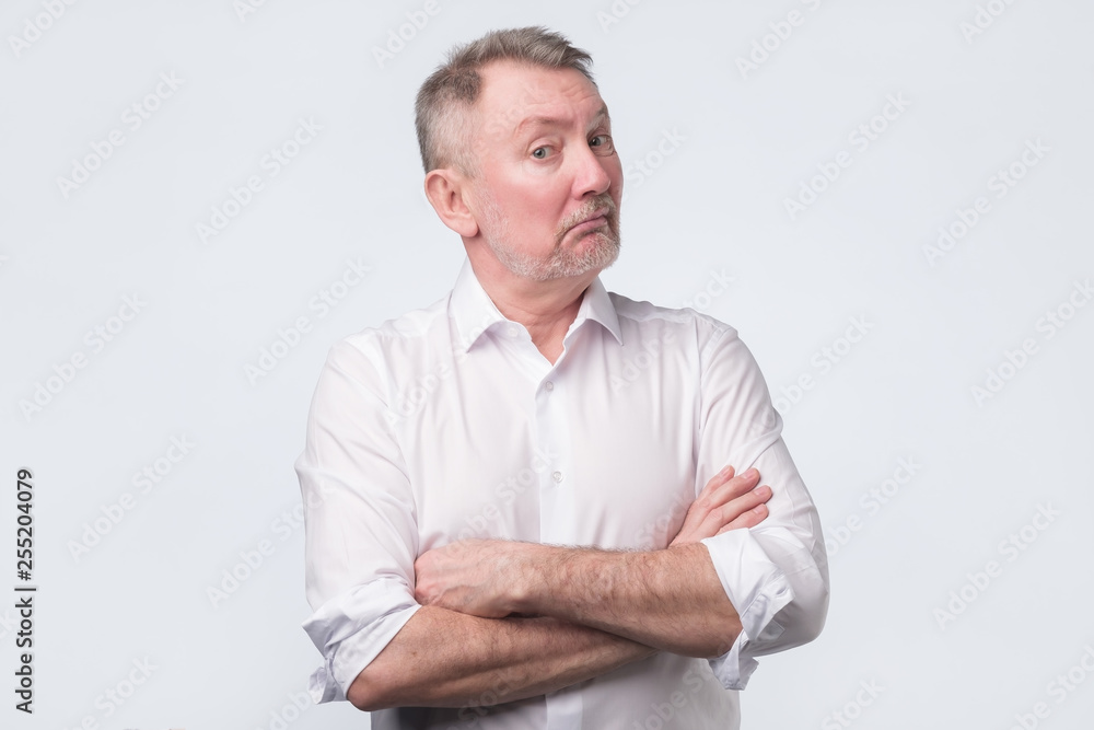 Doubtful senior man looking with disbelief expression.