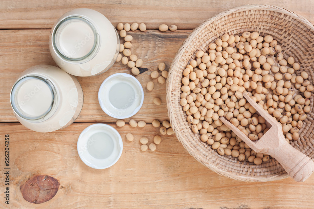 Bottle of soy milk and soy beans on wood background. Bottle of soy milk and soy beans on wood background.