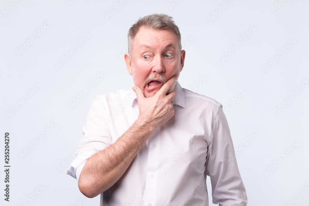Sad senior man in white shirt thinking abour life. Sad senior man in white shirt thinking abour life.