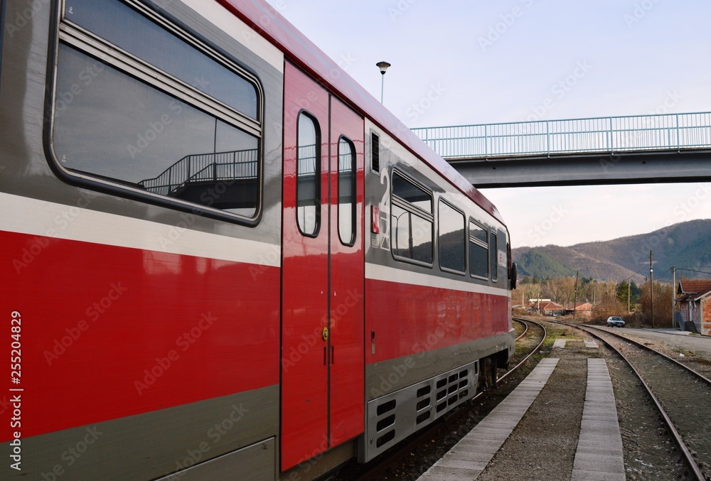 a red train in the station and an overpass