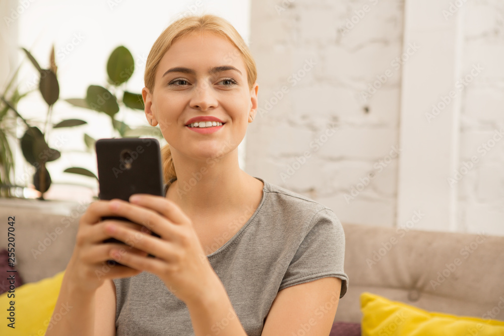 Young attractive woman smiling looking away while texting on her smart phone copyspace technology flirtatious flirt messaging connection mobility carrier online wireless internet student cafe coffee s Young attractive woman smiling looking away while texting on her smart phone copyspace technology flirtatious flirt messaging connection mobility carrier online wireless internet student cafe coffee s