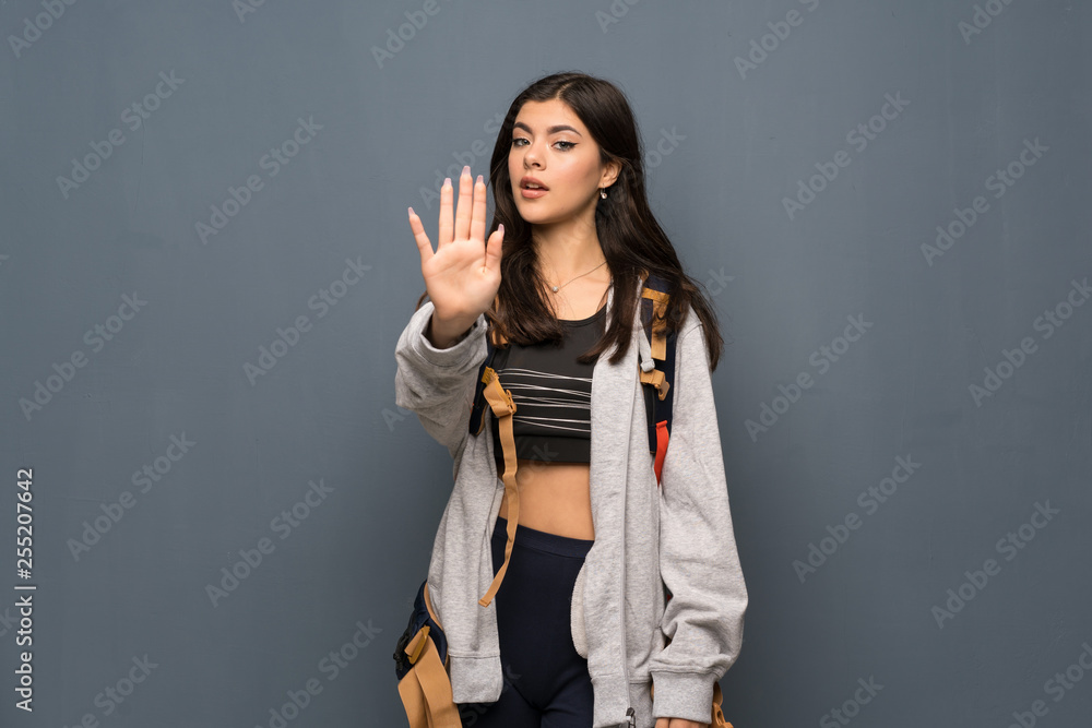 Teenager traveler girl over wall making stop gesture denying a situation that thinks wrong Teenager traveler girl over wall making stop gesture denying a situation that thinks wrong
