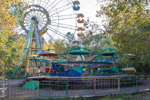 View on the ferris Wheel  Play and rest zone in the city park  called Kio. Covered by Trees  Flowers and Playground. Located Downtown of Temirtau  Karaganda Region. Kazakhstan.