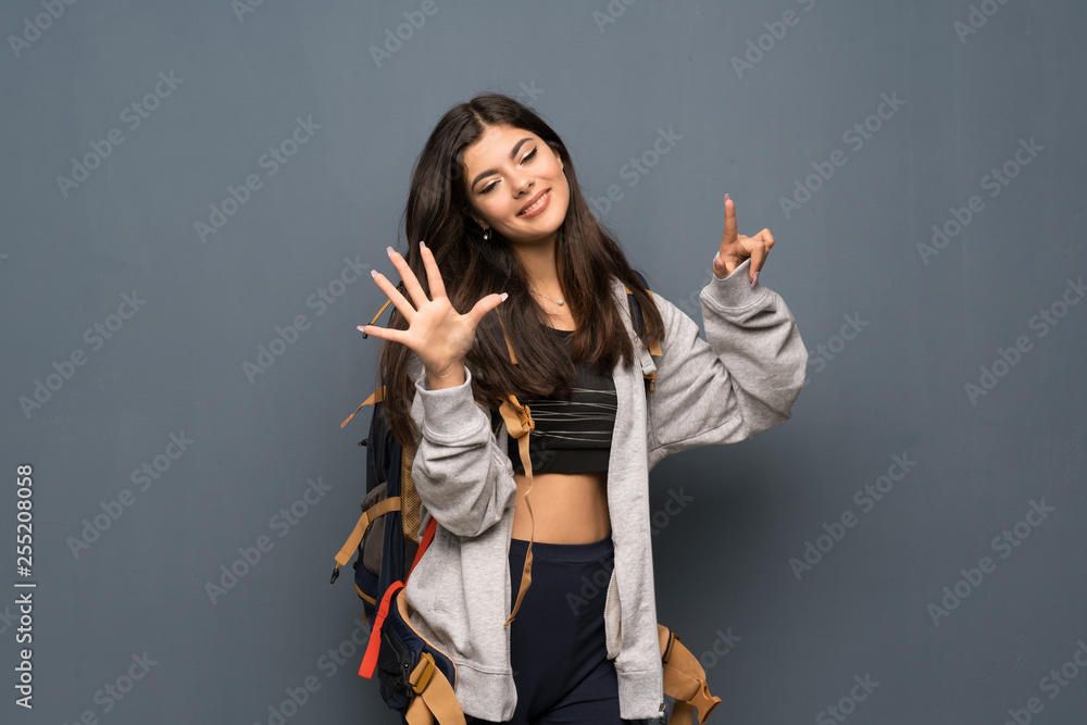 Teenager traveler girl over wall counting seven with fingers Teenager traveler girl over wall counting seven with fingers