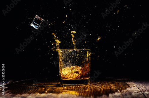 Isolated shot of whiskey with splash on black background