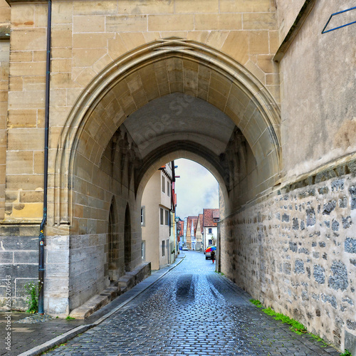 Ancient street. Nice arch. Old Town. Cobblestone road in a medieval city. West Europe.