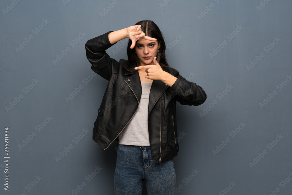 Teenager girl over grey wall focusing face. Framing symbol Teenager girl over grey wall focusing face. Framing symbol
