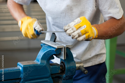 Handwerker feilt Metall, Werkstück im Schraubstock
