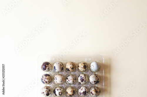 Plastic packaging with quail eggs on a yellow background.