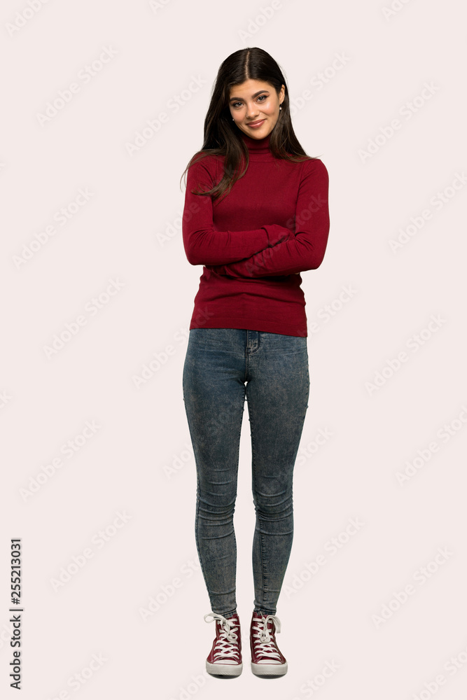 A full-length shot of a Teenager girl with turtleneck looking up while smiling over isolated background A full-length shot of a Teenager girl with turtleneck looking up while smiling over isolated background