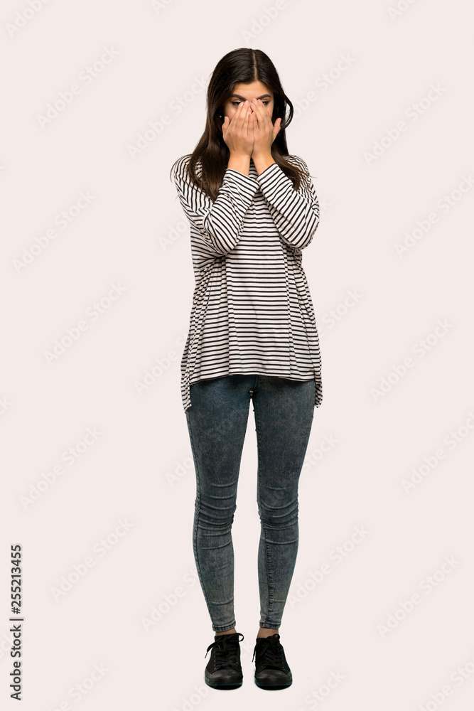 A full-length shot of a Teenager girl with striped shirt smiling a lot over isolated background A full-length shot of a Teenager girl with striped shirt smiling a lot over isolated background