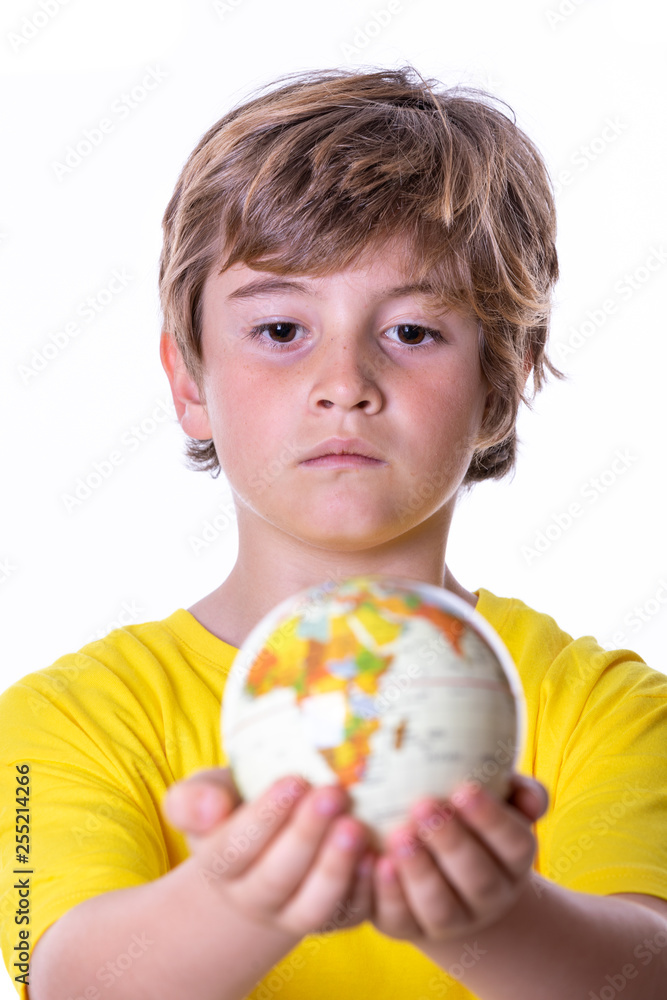 Young boy with yellow T-shirt, aviator goggles, plane and world ball smiling Young boy with yellow T-shirt, aviator goggles, plane and world ball smiling