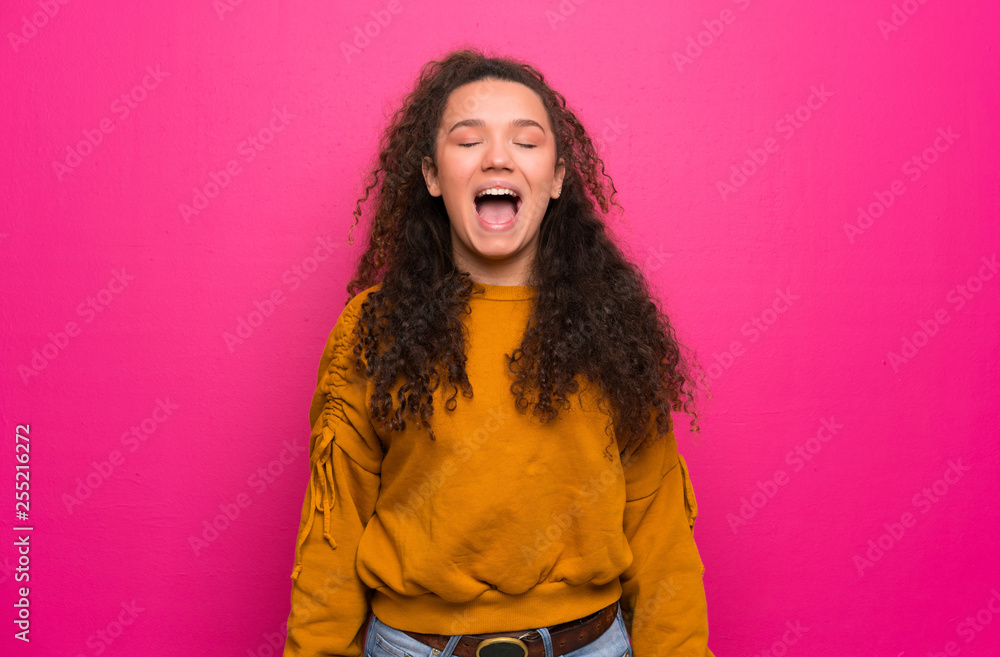 Teenager girl over pink wall shouting to the front with mouth wide open Teenager girl over pink wall shouting to the front with mouth wide open