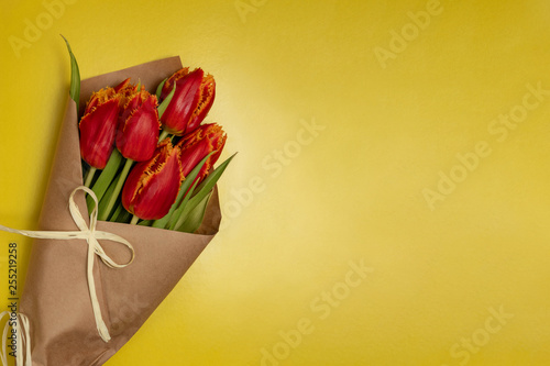 Boquet of red tulips on the yellow background