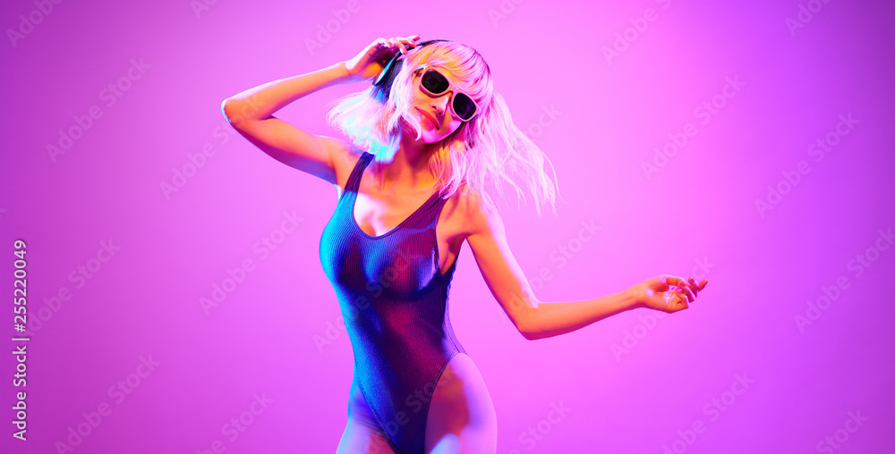 Shapely fashionable DJ girl dance enjoy music in colorful neon uv purple light. Rave house music night club vibes. High Fashion. Young blonde model woman relax enjoy dancing, neon makeup. Shapely fashionable DJ girl dance enjoy music in colorful neon uv purple light. Rave house music night club vibes. High Fashion. Young blonde model woman relax enjoy dancing, neon makeup.