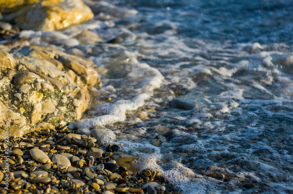 pebble stones on the sea beach, the rolling waves of the sea with foam pebble stones on the sea beach, the rolling waves of the sea with foam