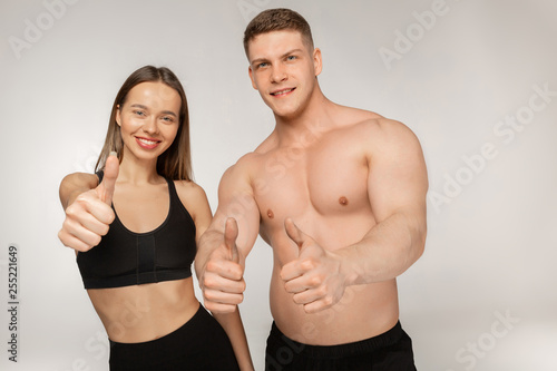 Athletic man with naked torso and beautiful woman after fitness exercises