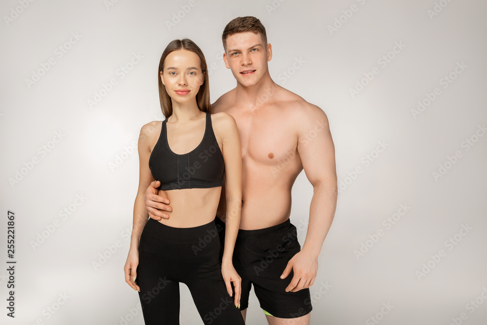 Young athletic shirtless man and beautiful woman in black sportswear Young athletic shirtless man and beautiful woman in black sportswear