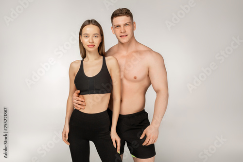Young athletic shirtless man and beautiful woman in black sportswear