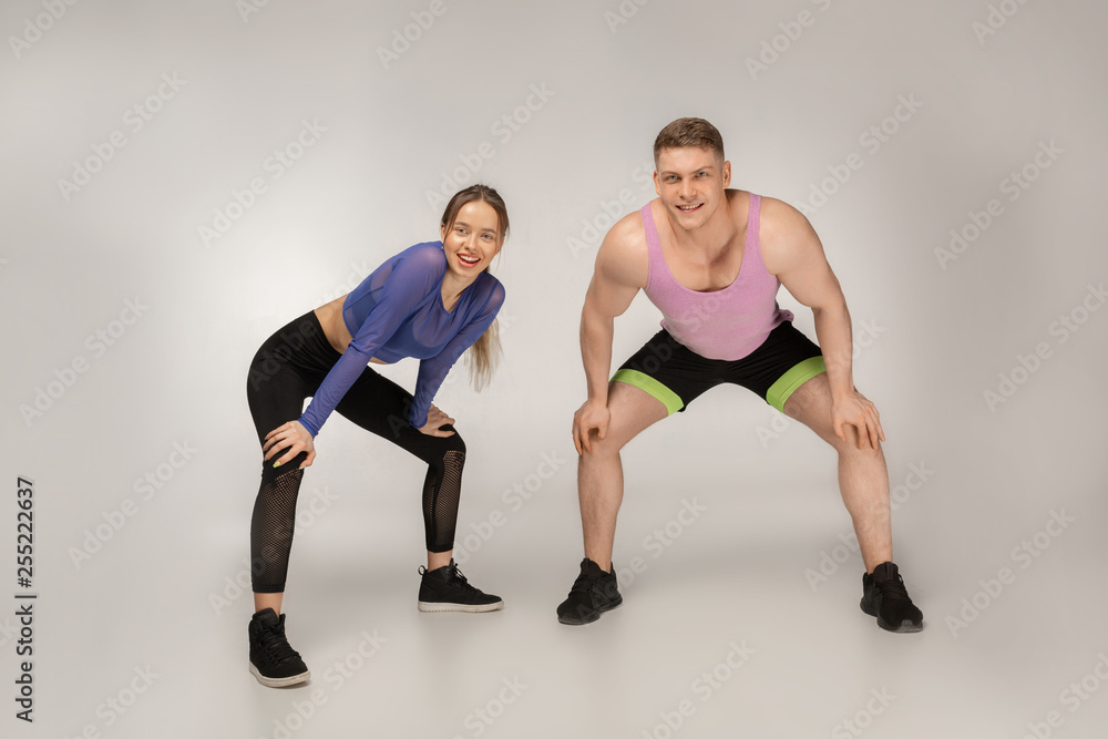 Young sporty couple in colorful sportswear resting after training