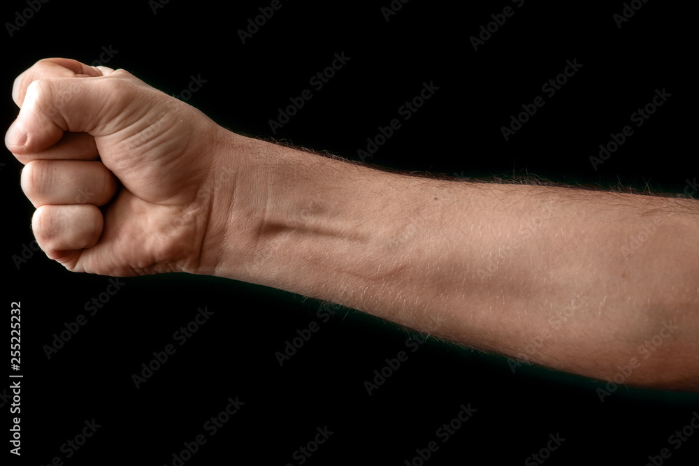 Fist isolated on black background. A strong man raised his fist on a black background, power, protest, fist ready for battle. Fist isolated on black background. A strong man raised his fist on a black background, power, protest, fist ready for battle.