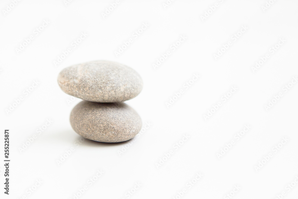 Two pebbles against each other on the white ground Two pebbles against each other on the white ground