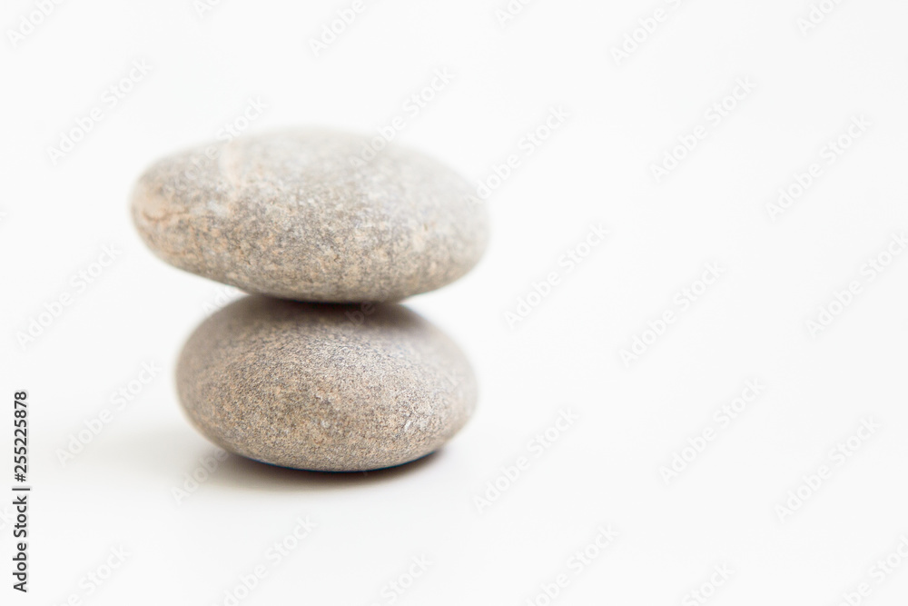 Two pebbles against each other on the white ground Two pebbles against each other on the white ground