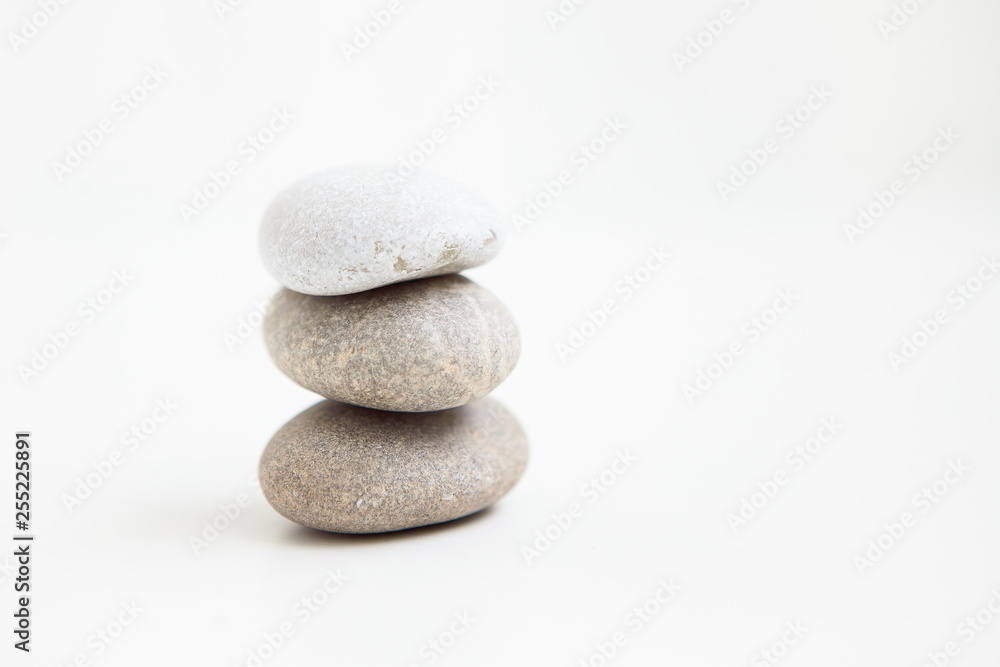 Three pebbles against each other on the white ground Three pebbles against each other on the white ground