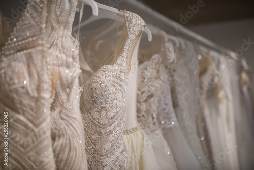 Wedding dresses hang on hangers. Factory of wedding dresses. Fototapeta