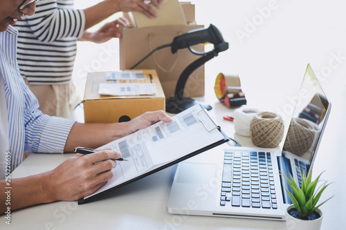 Shipment Online Sales, Small business or SME entrepreneur owner delivery service and working packing box, business owner working checking order to confirm before sending customer in post office photo