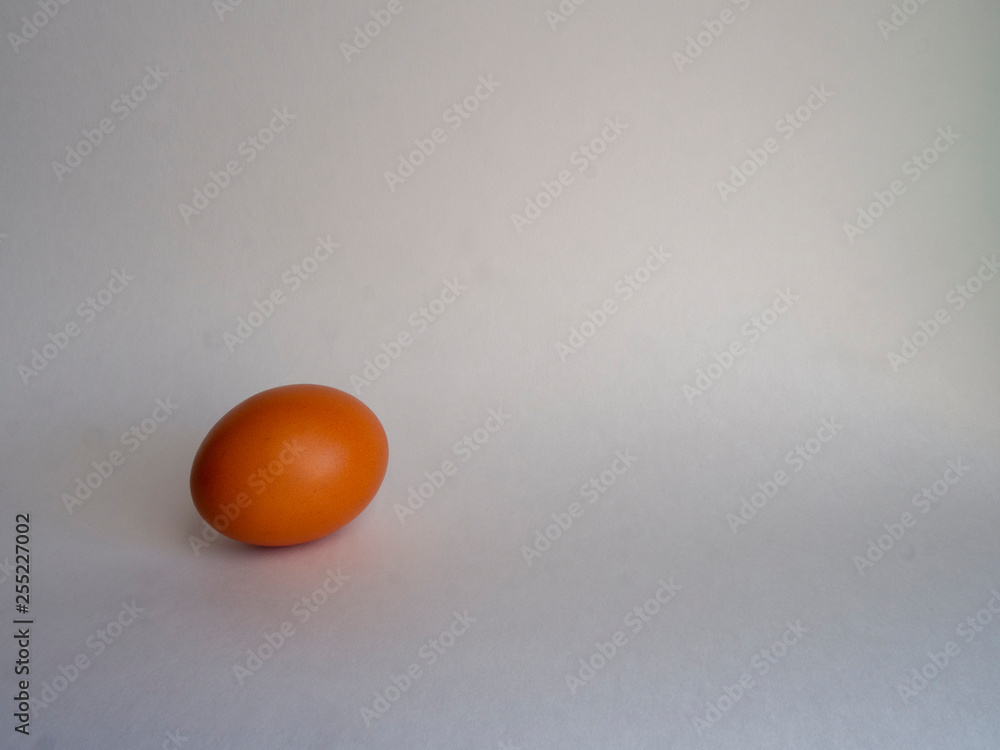 Brown egg of light color prepares for the holiday Easter on a white background.
