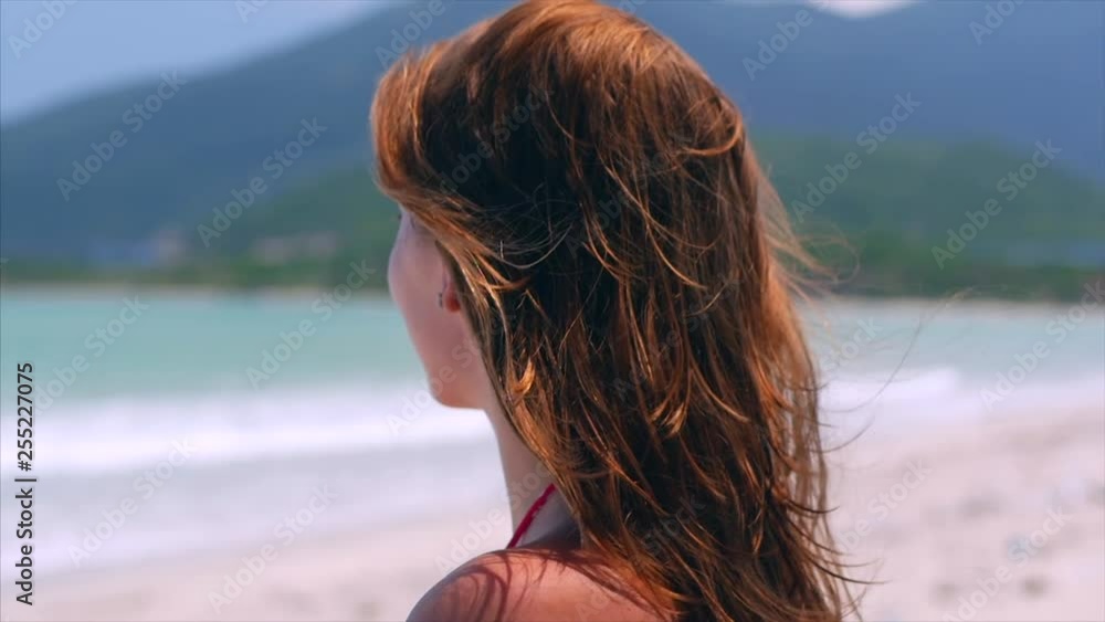 Portrait Close-Up of a Beautiful European Woman on the Beach, Looking into the Distance at the Sea, Relaxing at the Sea in the Summer. Stock Footage. Portrait Close-Up of a Beautiful European Woman on the Beach, Looking into the Distance at the Sea, Relaxing at the Sea in the Summer. Stock Footage.