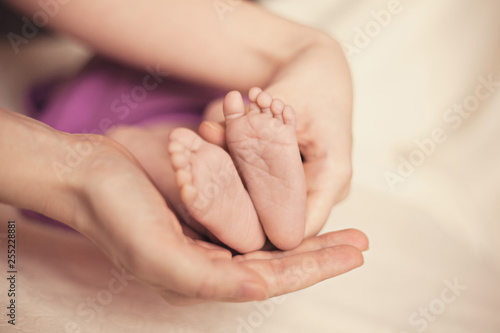 Baby's foot in mother hands closeup on the bed, New family and baby healthy concept