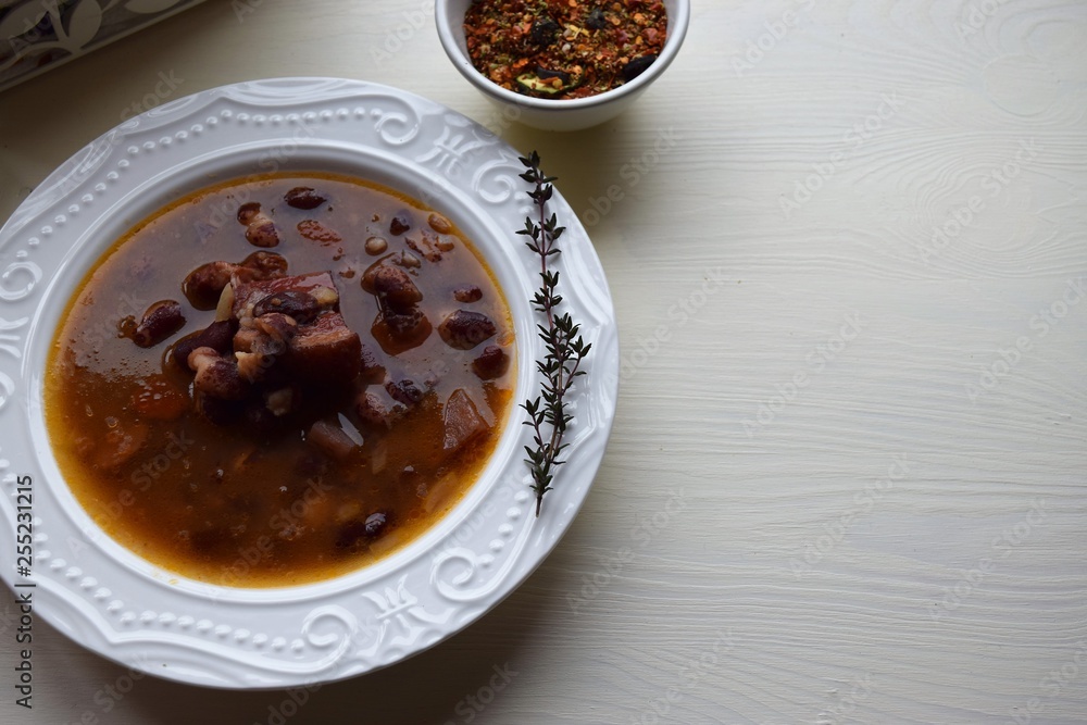 Homemade bean soup , vegetables ,bacon and spices. Detail of bowl of bean soup with large beans Homemade bean soup , vegetables ,bacon and spices. Detail of bowl of bean soup with large beans