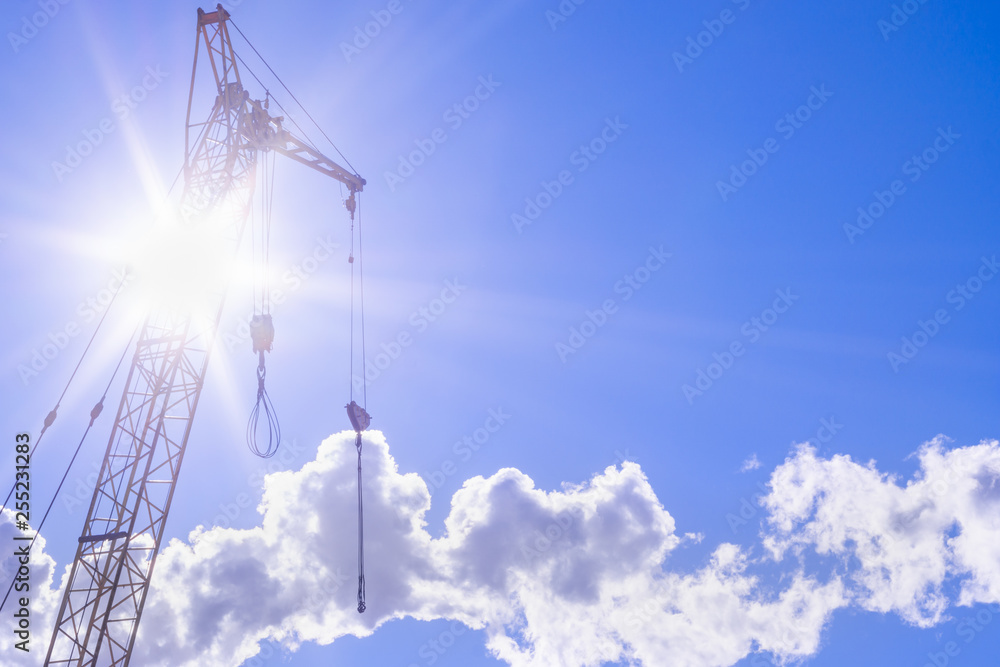 Obraz premium construction crane on a bright Sunny day concept of building and construction of houses