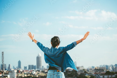 Happy woman raising hands in the city scene background with copy space- feel good- relax and freedom concept