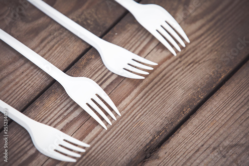 Plastic forks on wooden background,  plastic free concept