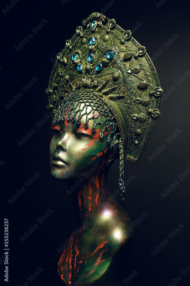 Black head of mannequin in decorated green kokoshnick, dark studio background Black head of mannequin in decorated green kokoshnick, dark studio background