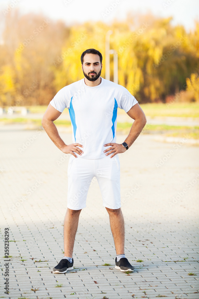 Fitness. Tired man runner rest after running on city stree
