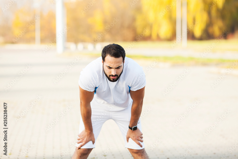 Fitness. Tired man runner rest after running on city stree Fitness. Tired man runner rest after running on city stree