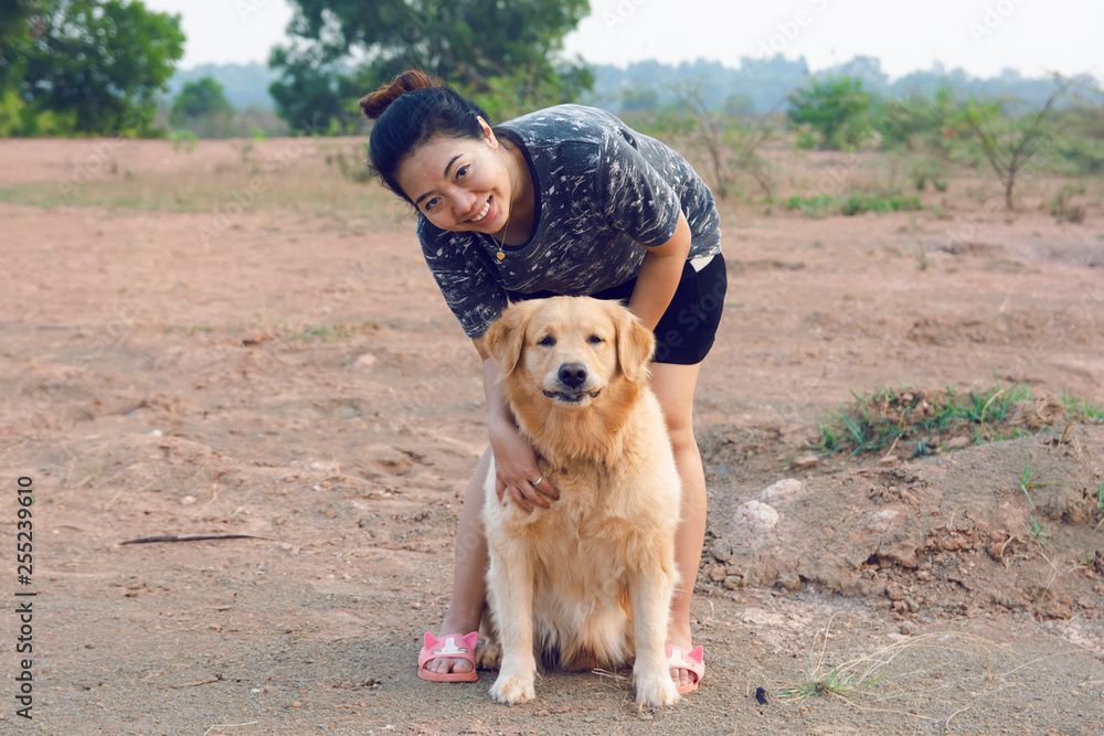 Woman with her golden retriever dog playing outdoors.
